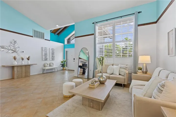 Tiled living room with a fireplace and high vaulted ceiling