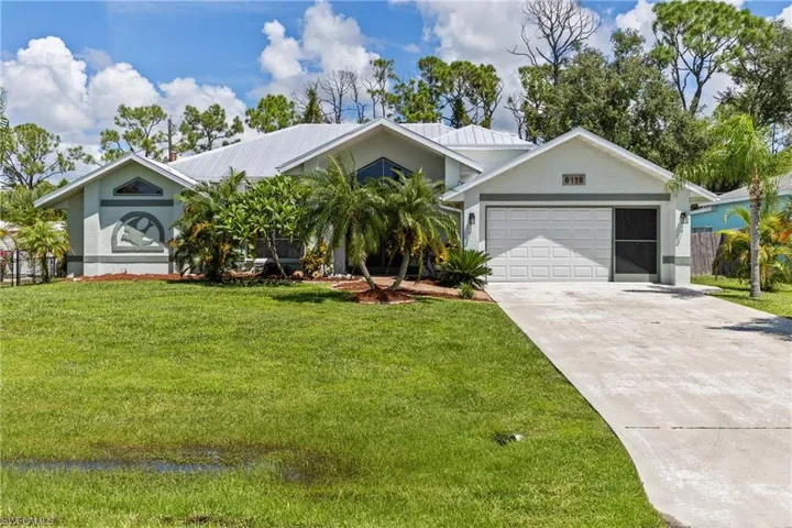 Ranch-style home with a garage and a front lawn