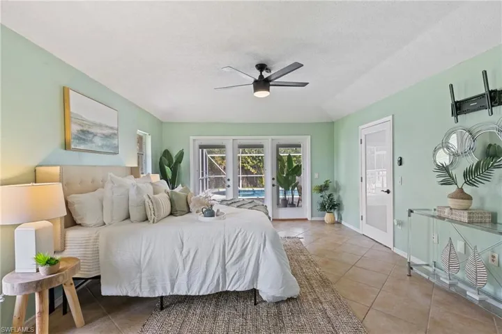 Bedroom featuring tile patterned floors, a textured ceiling, access to outside, ceiling fan, and french doors