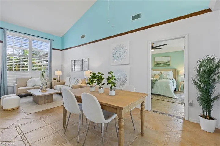 Dining area with ceiling fan, high vaulted ceiling, and light tile patterned flooring