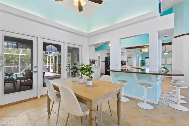 Dining area featuring french doors, high vaulted ceiling, light tile patterned flooring, and ceiling fan