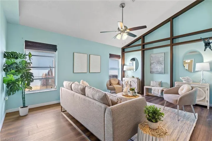 Living room featuring ceiling fan, dark hardwood / wood-style floors, and high vaulted ceiling