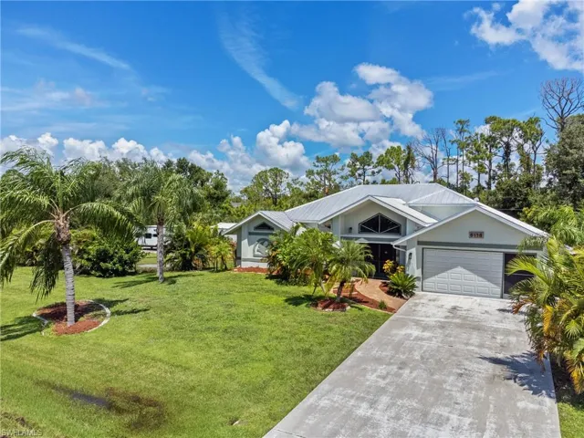 View of front of home with a garage and a front lawn