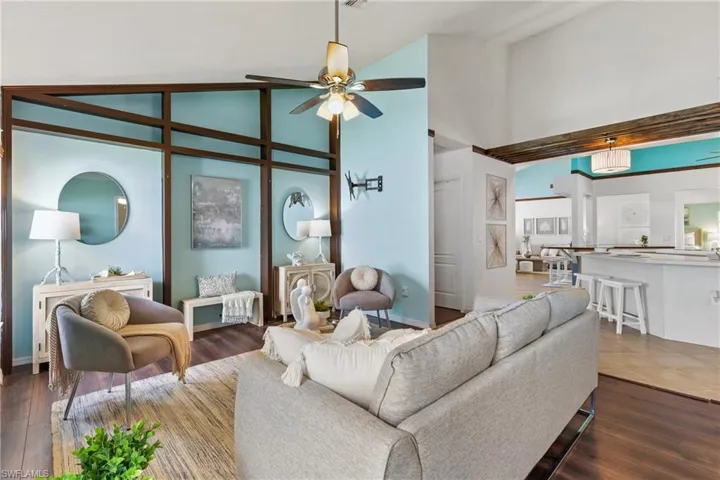 Living room featuring high vaulted ceiling, ceiling fan, and dark hardwood / wood-style floors