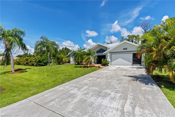 View of front of house with a garage and a front lawn