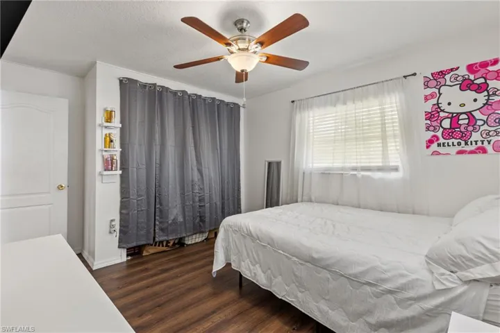 Bedroom featuring dark wood-type flooring, a textured ceiling, and ceiling fan