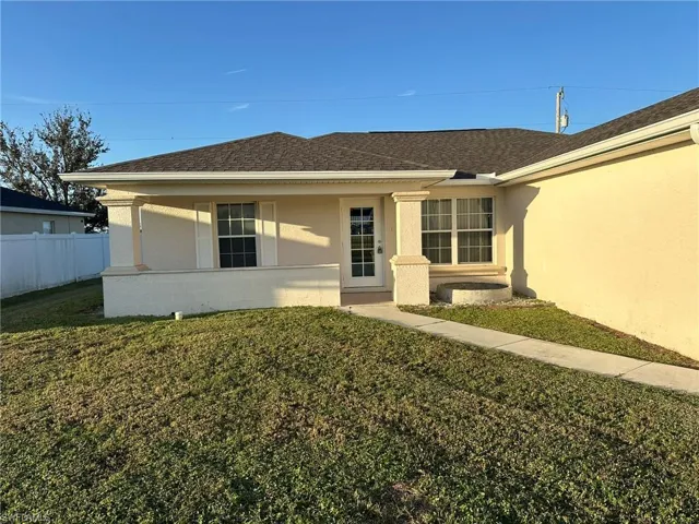 View of front facade featuring stucco siding and roof with shingles