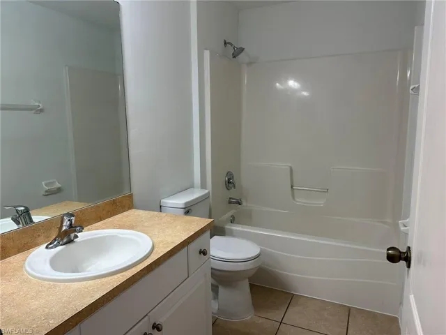 Full bathroom featuring vanity, light tile patterned floors, and shower / bathtub combination