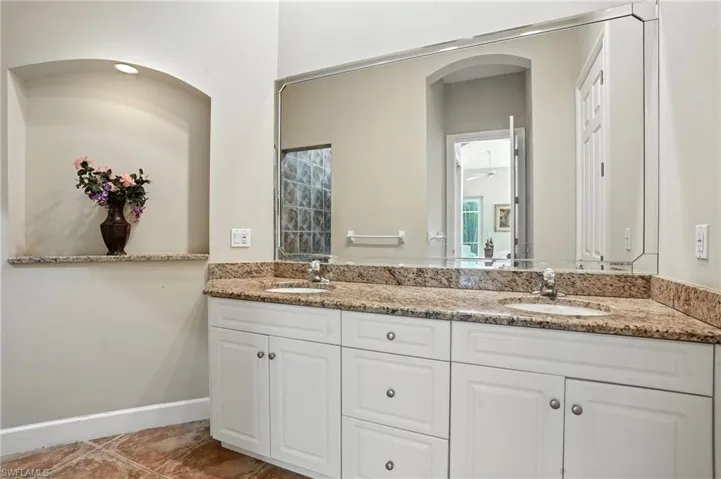 Full bathroom with double vanity, tile patterned flooring, and ceiling fan