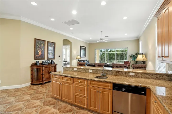 Kitchen featuring crown molding, a peninsula, dishwasher, arched walkways, and open floor plan
