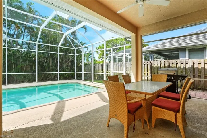 View of swimming pool featuring a patio area, a lanai, a sunroom, a ceiling fan, and outdoor dining area