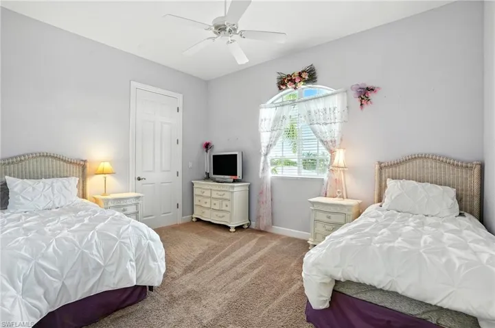 Bedroom with light colored carpet and a ceiling fan
