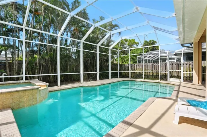 View of swimming pool featuring glass enclosure, a sunroom, a patio, and a pool with connected hot tub