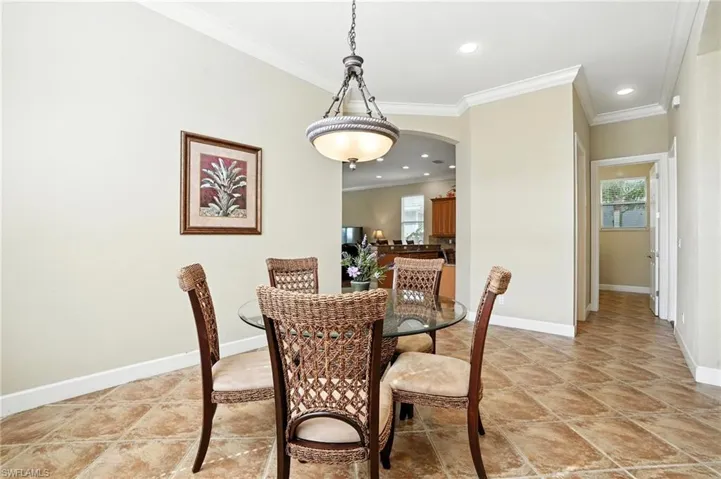 Dining room with crown molding, recessed lighting, and arched walkways