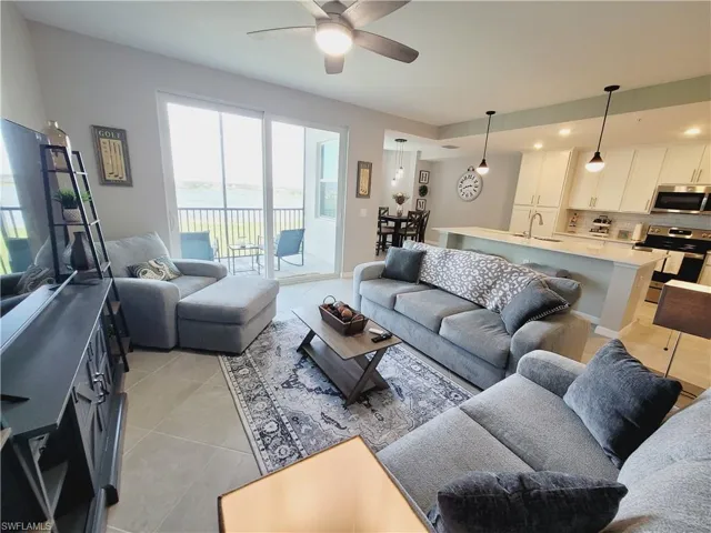 Tiled living room featuring ceiling fan and sink