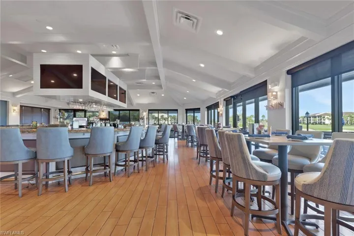 Bar area with vaulted ceiling with beams and recessed lighting