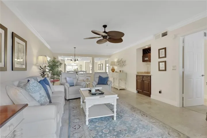 Living area featuring ornamental molding, ceiling fan, and hanging lights