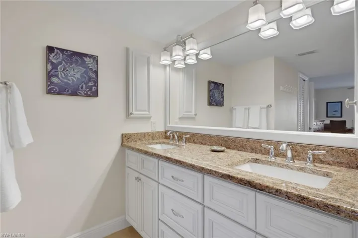 Bathroom featuring double vanity and baseboards