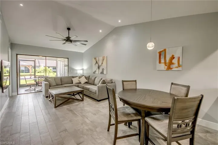 Dining room with high vaulted ceiling, light hardwood / wood-style flooring, and ceiling fan