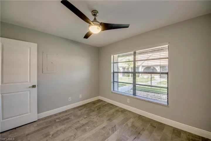 Spare room with ceiling fan, light wood-type flooring, and electric panel