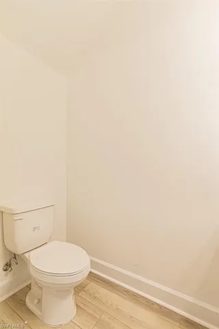 Bathroom with hardwood / wood-style floors and toilet