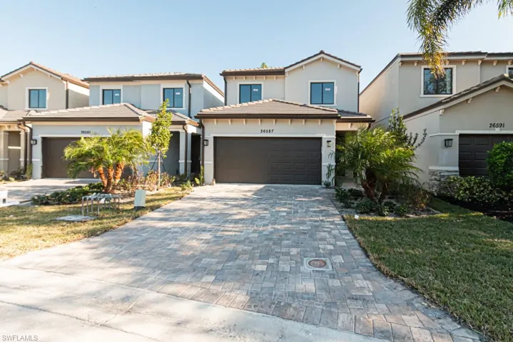 View of front of house with a garage and a front yard