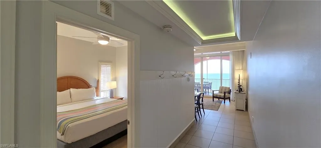 Hall featuring plenty of natural light, light tile patterned flooring, and a water view