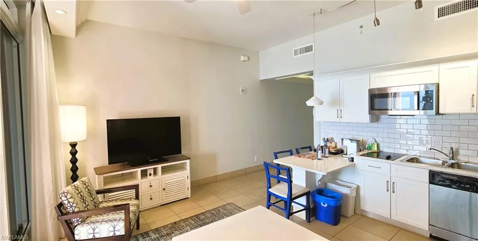 Kitchen featuring white cabinetry, stainless steel appliances, light countertops, and tasteful backsplash