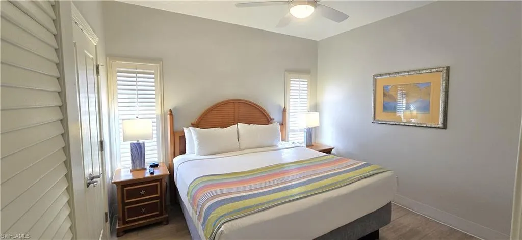 Bedroom with multiple windows, ceiling fan, and wood finished floors