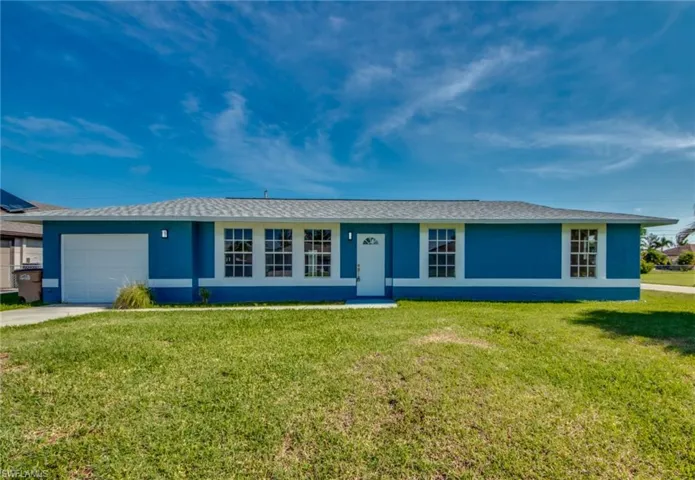 Ranch-style home with stucco siding, a garage, and a front yard