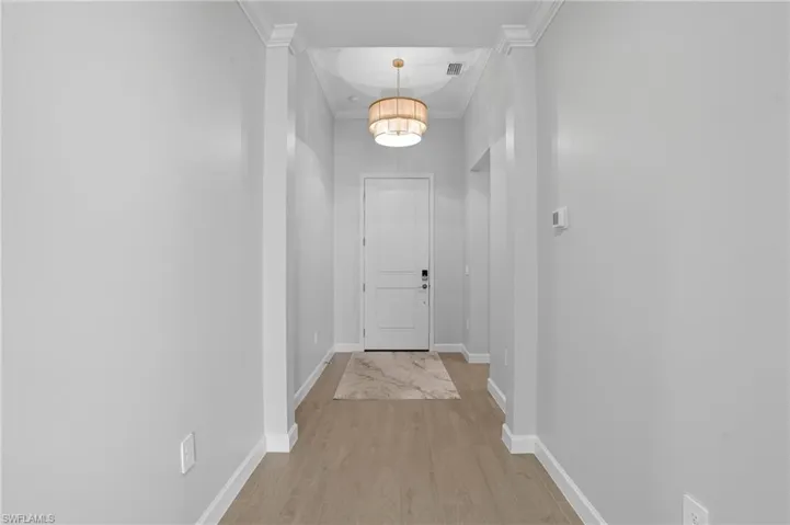Hallway featuring light wood-style floors and crown molding