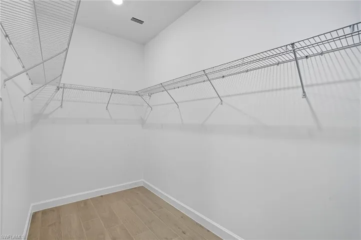 Spacious closet with light wood finished floors