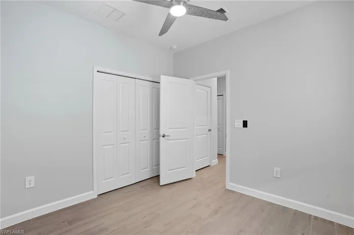 Unfurnished bedroom with light wood-style floors, a closet, and ceiling fan