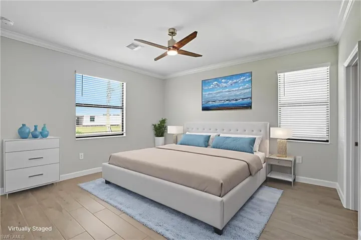 Bedroom with ornamental molding, light wood-style flooring, and ceiling fan