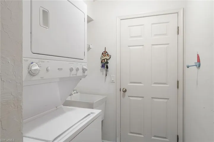 Laundry room with stacked washer / dryer and laundry tub