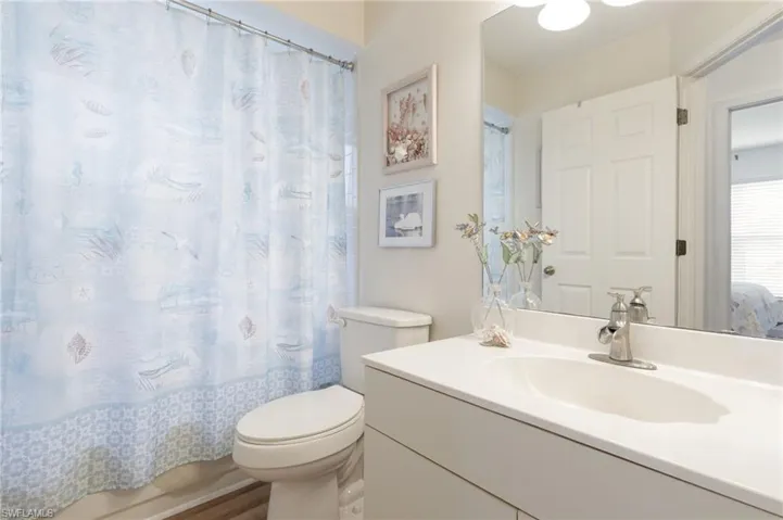 Guest Bathroom featuring toilet and vanity with extensive cabinet space