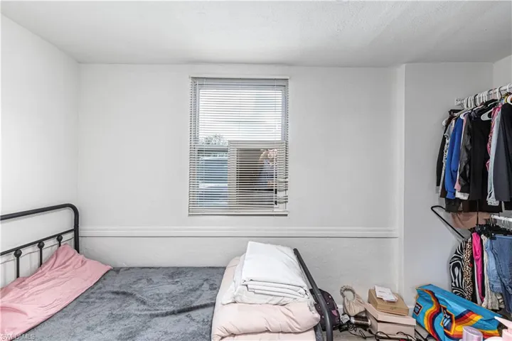 Unit B)Bedroom featuring carpet floors, a textured ceiling, and a textured wall