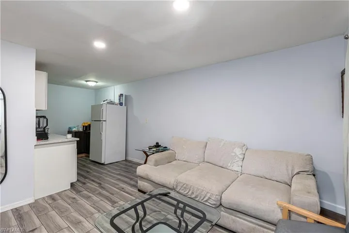 Unit A)Living area featuring wood tiled floors and recessed lighting