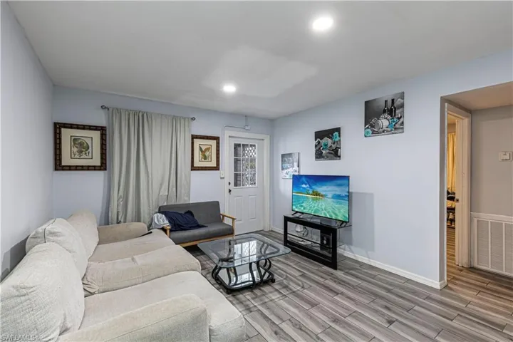 Unit A)Living area with recessed lighting and wood tiled floors