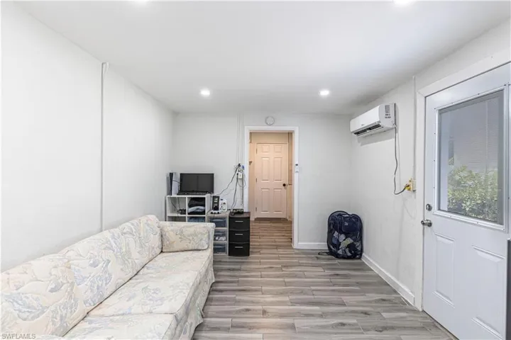 Unit B)Living room featuring light wood finished floors and recessed lighting
