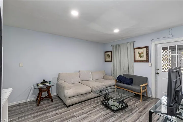 Unit A)Living room featuring wood finish floors and recessed lighting