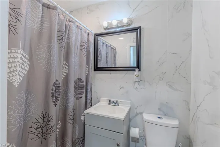 Unit C)Bathroom featuring a shower with shower curtain and vanity
