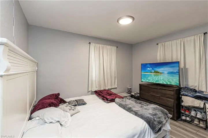 Unit A)Bedroom featuring wood finished floors