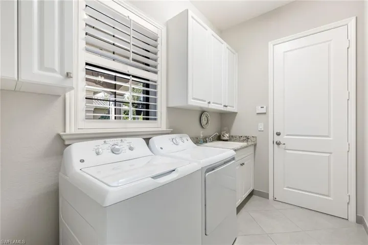 Laundry room with sink and storage cabinets