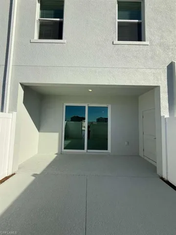Entrance to property featuring stucco siding and a patio area