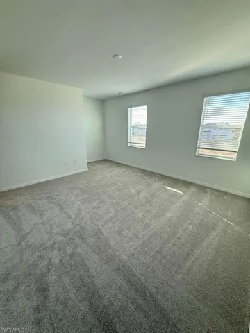 Carpeted spare room with baseboards