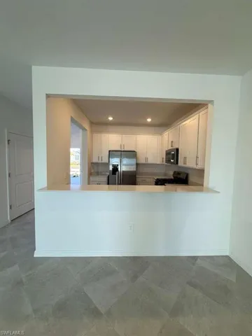 Kitchen featuring white cabinetry, stainless steel appliances, a peninsula, and recessed lighting