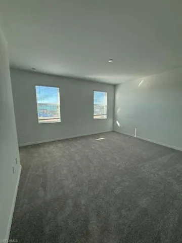 Carpeted empty room with baseboards