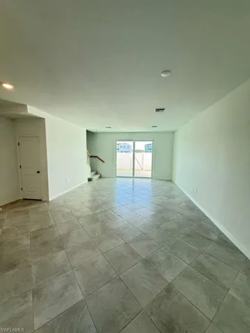 Spare room featuring baseboards and light tile patterned flooring