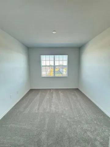 Unfurnished room featuring carpet floors and baseboards